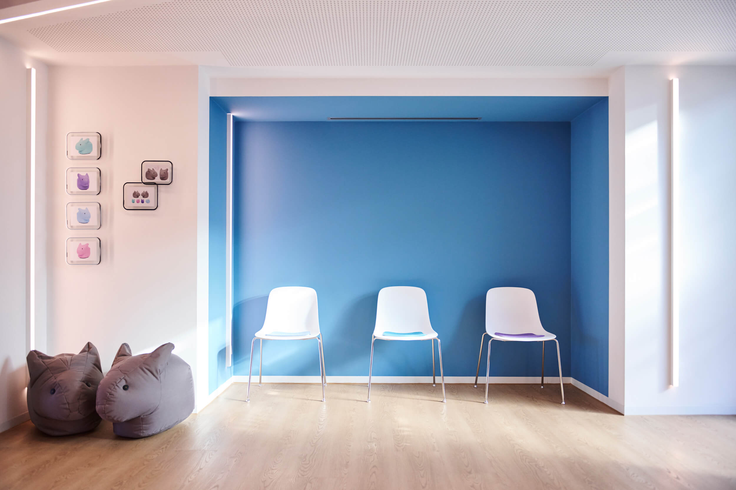 Im Wartezimmer der kieferorthopädischen Praxis formbar in Forchheim stehen drei Stühle vor einer blauen Wand