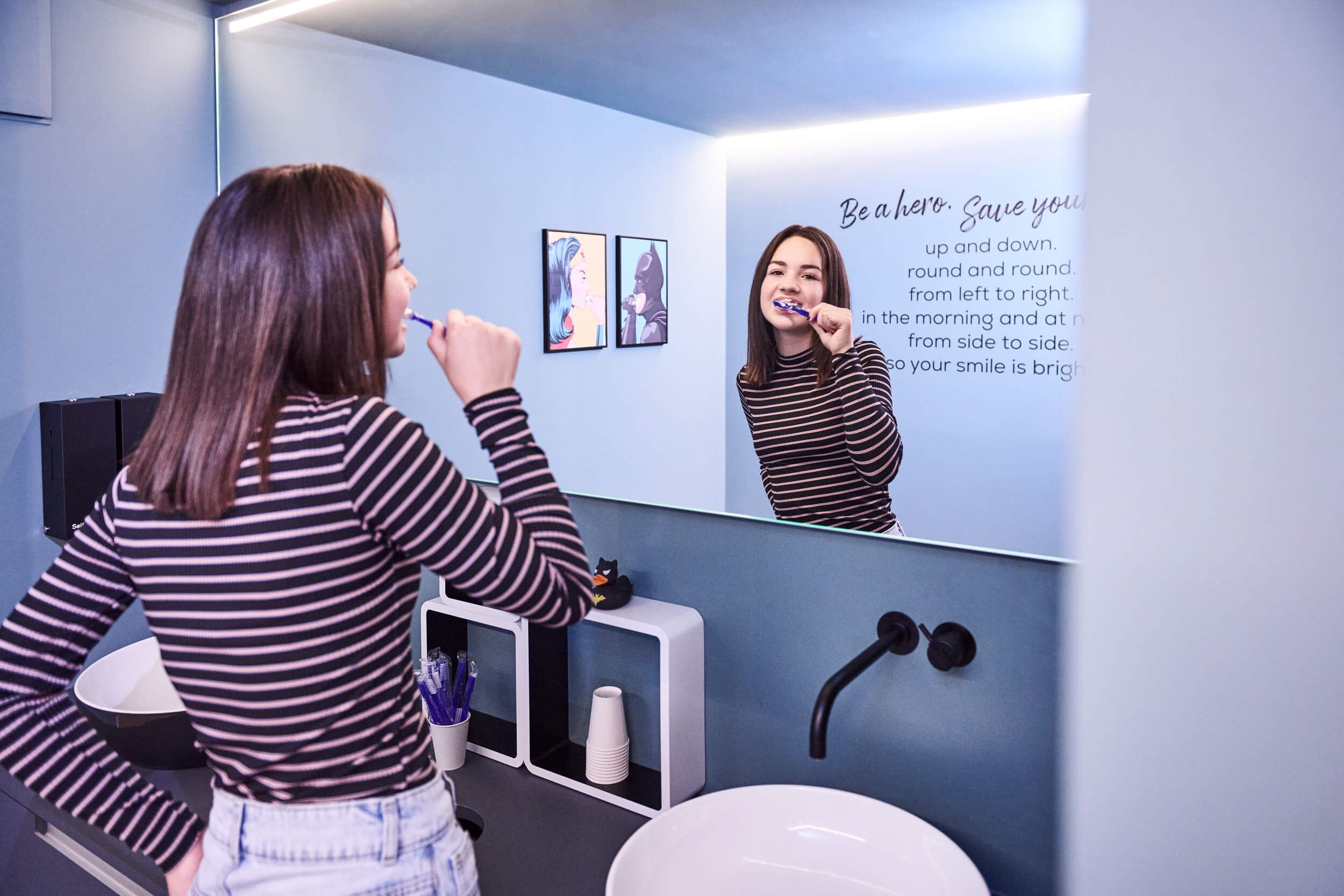 Ein Mädchen putzt sich vor ihrer Behandlung bei Kieferorthopädin Dr. Christina Rathe im Badezimmer der Praxis formbar in Forchheim die Zähne